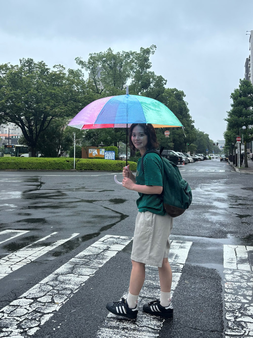 グリーン系のTシャツ/カットソー、ホワイト系のパンツ、ブラック系のスニーカーを着用したレディースの夏コーディネートの3枚目の写真