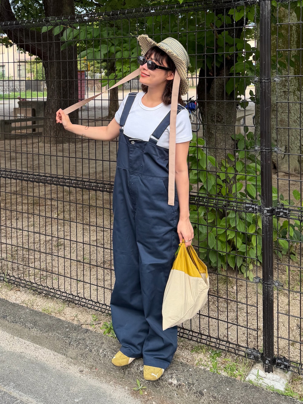 ホワイト系のTシャツ/カットソー、ブルー系のオールインワン・サロペット、イエロー系のバッグを着用したレディースの夏コーディネートの2枚目の写真