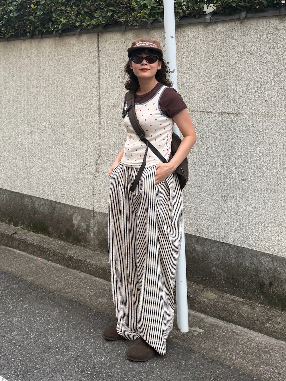 ブラウン系のTシャツ/カットソー、レッド系のタンクトップ、ホワイト系のパンツを着用したレディースの夏コーディネートの2枚目の写真
