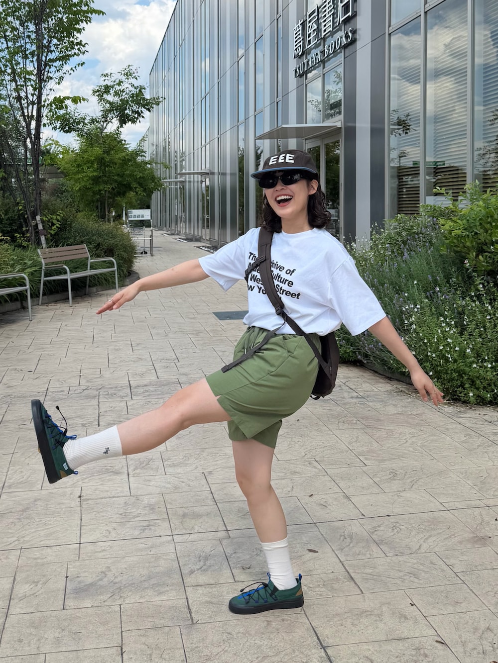 ホワイト系のTシャツ/カットソー、グリーン系のパンツ、ブラウン系のショルダーバッグを着用したレディースの春コーディネートの2枚目の写真