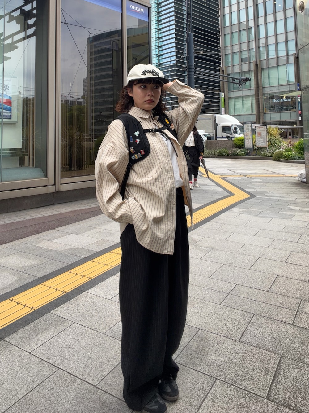 ブラック系のバックパック/リュック、ホワイト系のTシャツ/カットソー、ベージュ系のシャツ/ブラウスを着用したレディースの春コーディネートの2枚目の写真