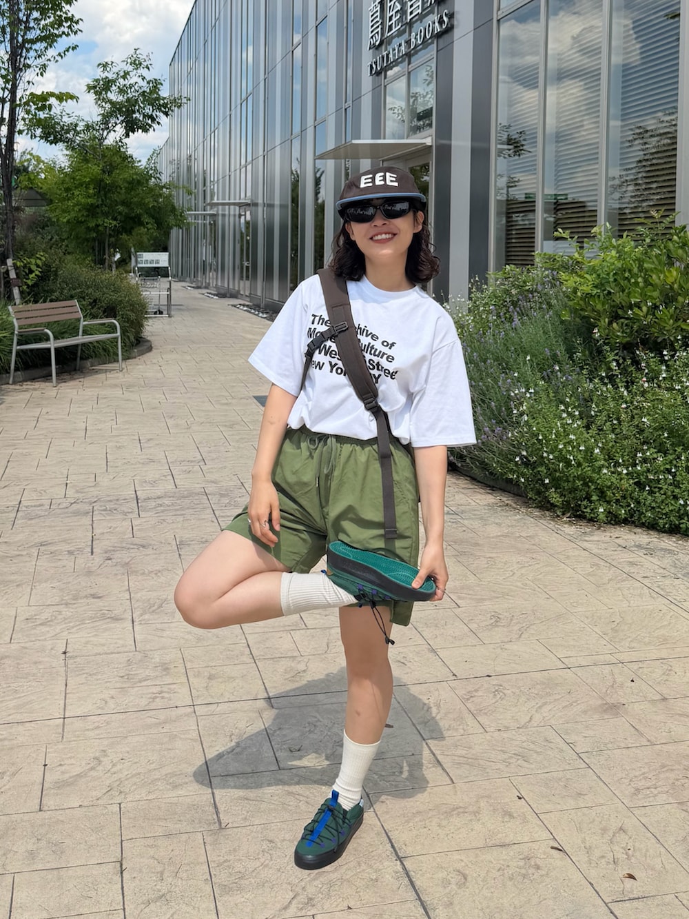 ホワイト系のTシャツ/カットソー、グリーン系のパンツ、ブラウン系のショルダーバッグを着用したレディースの春コーディネートの3枚目の写真