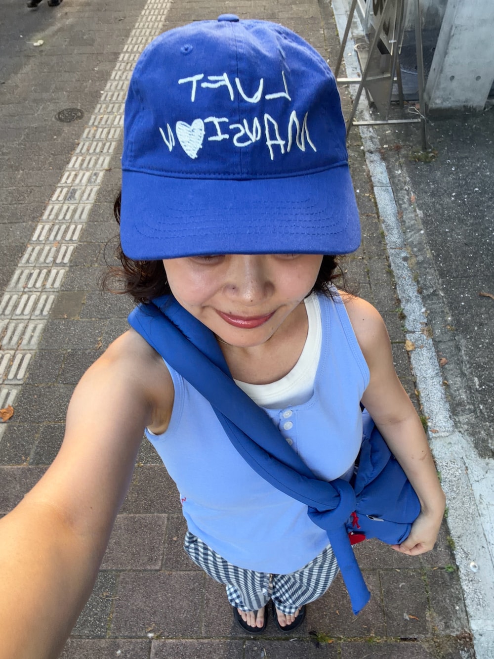 ブルー系のタンクトップ、ブルー系のハンドバッグ、ブルー系のパンツを着用したレディースの夏コーディネートの2枚目の写真