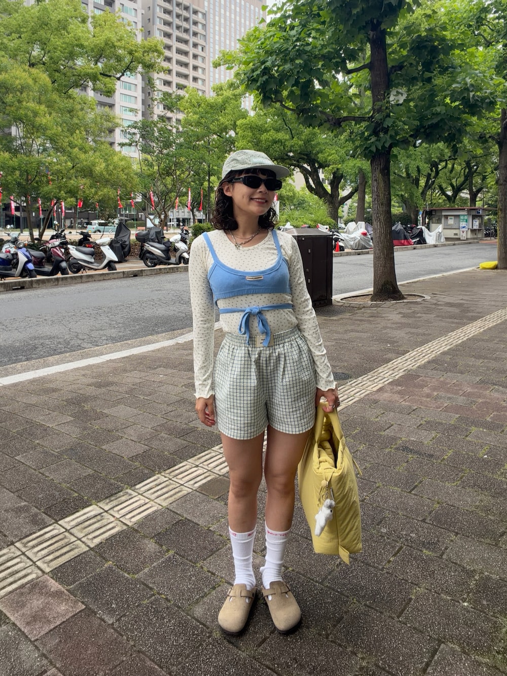 ブルー系のキャミソール、ホワイト系のトップス、イエロー系のその他パンツを着用したレディースの夏コーディネートの2枚目の写真