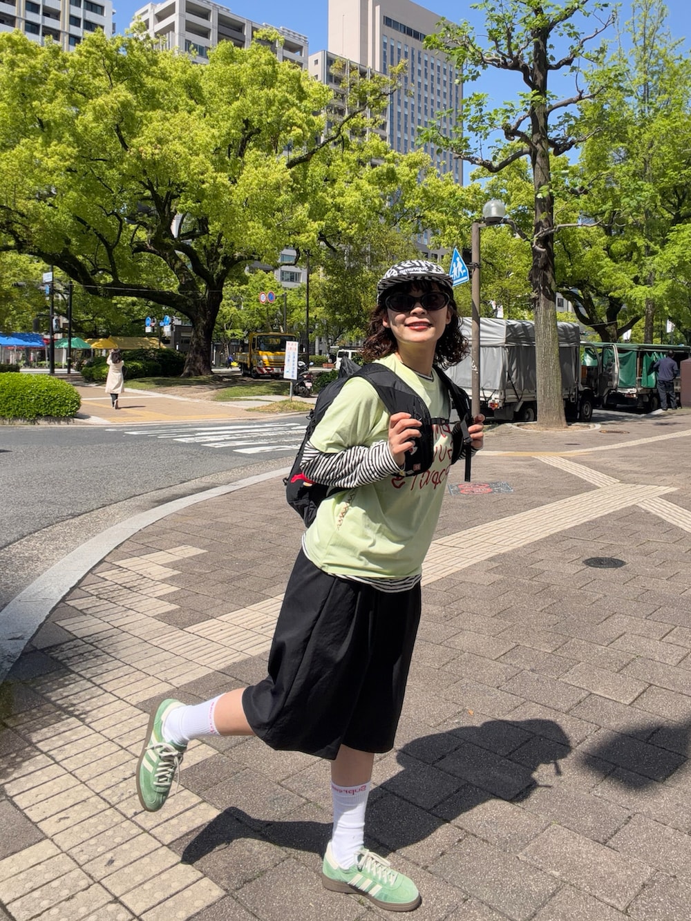 グリーン系のスニーカー、グリーン系のTシャツ/カットソー、ブラック系のバックパック/リュックを着用したレディースの春コーディネートの3枚目の写真
