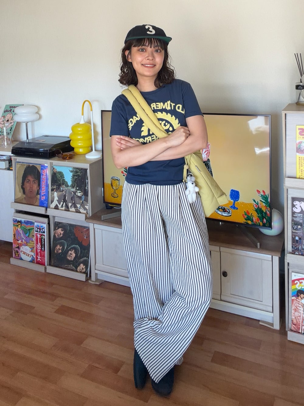 ブルー系のトップス、イエロー系のハンドバッグ、ホワイト系のパンツを着用したレディースの夏コーディネートの2枚目の写真