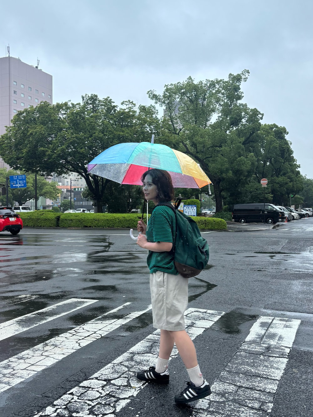 グリーン系のTシャツ/カットソー、ホワイト系のパンツ、ブラック系のスニーカーを着用したレディースの夏コーディネートの2枚目の写真