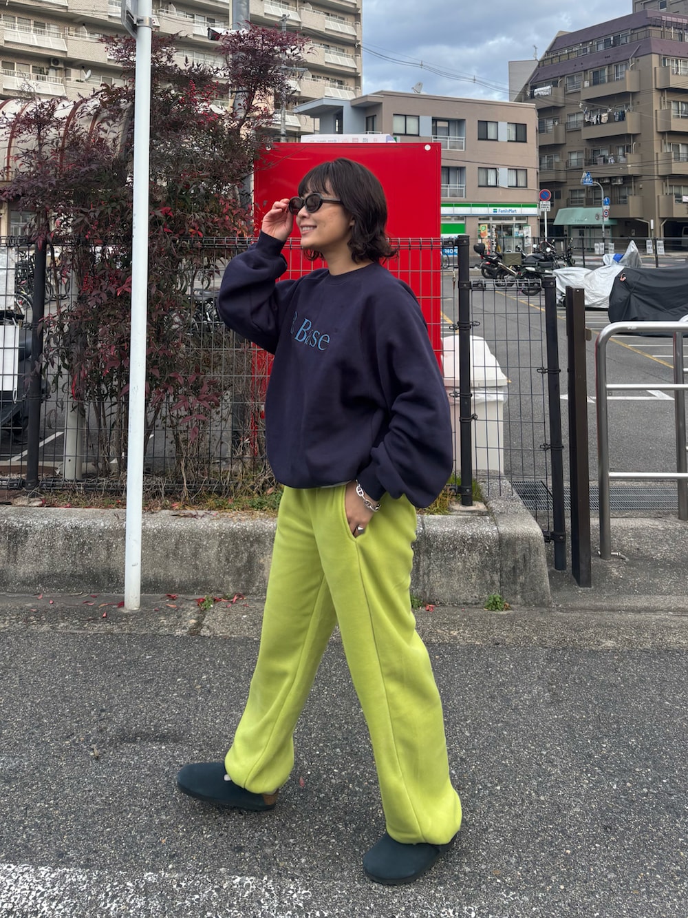 ブルー系のスウェット、グリーン系のパンツ、ブルー系のサンダルを着用したレディースの冬コーディネートの2枚目の写真