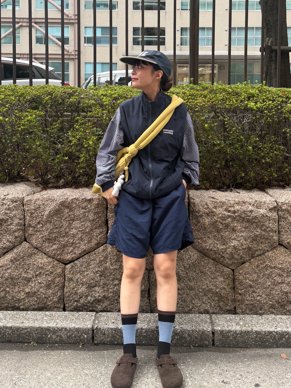 ブルー系のTシャツ/カットソー、イエロー系のハンドバッグ、ブルー系のベストを着用したレディースの秋コーディネートの2枚目の写真