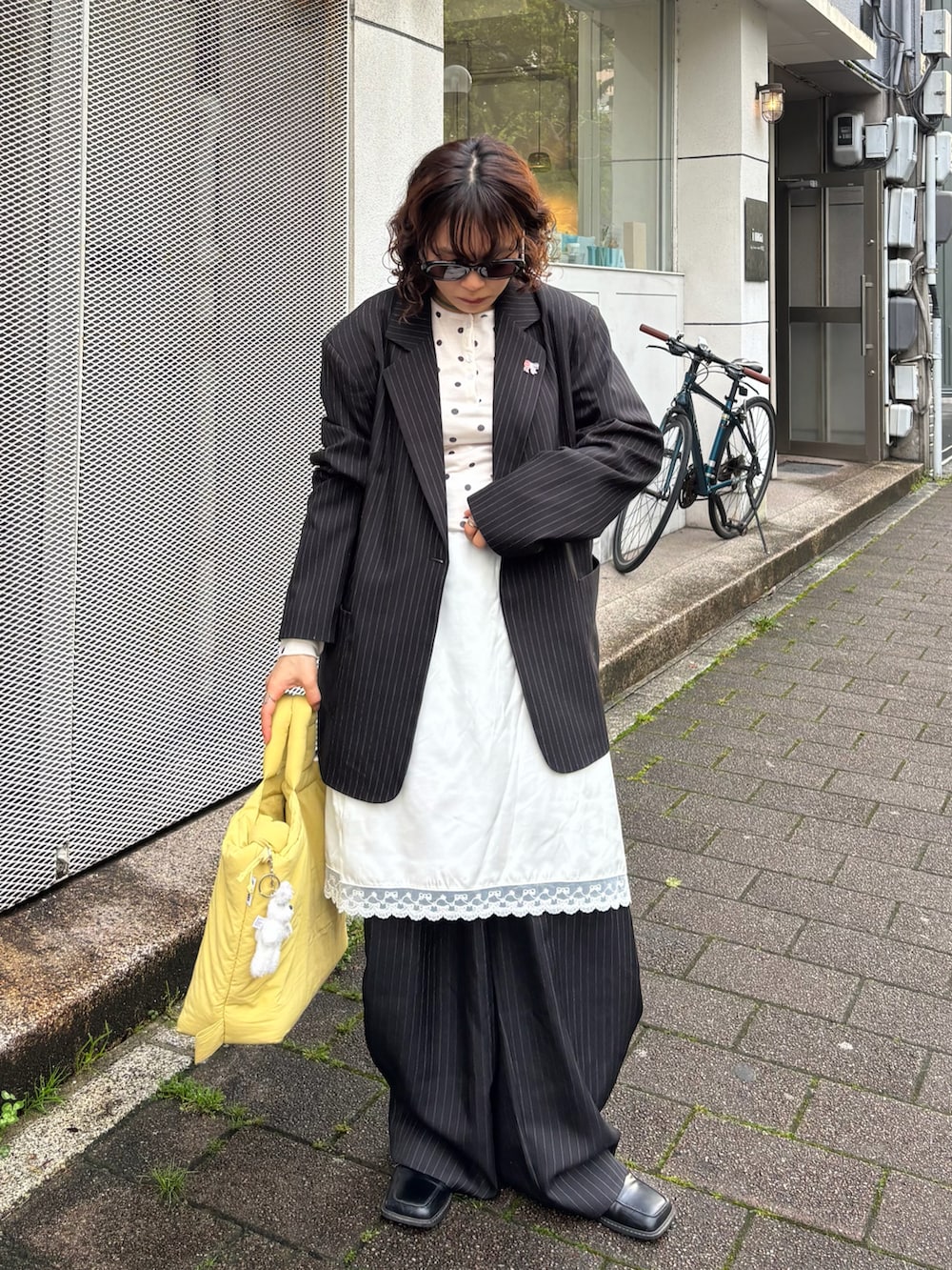 ブラック系のジャケット/アウター、ホワイト系のスカート、ホワイト系のトップスを着用したレディースの春コーディネートの2枚目の写真