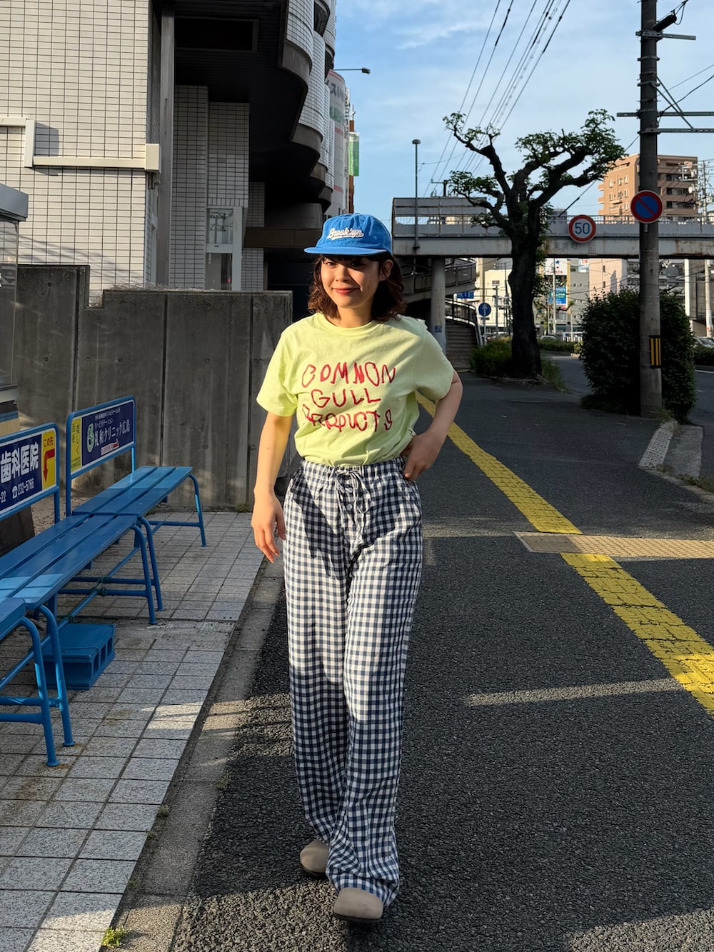 グリーン系のTシャツ/カットソー、ブルー系のパンツ、ベージュ系のサンダルを着用したレディースの春コーディネートの3枚目の写真