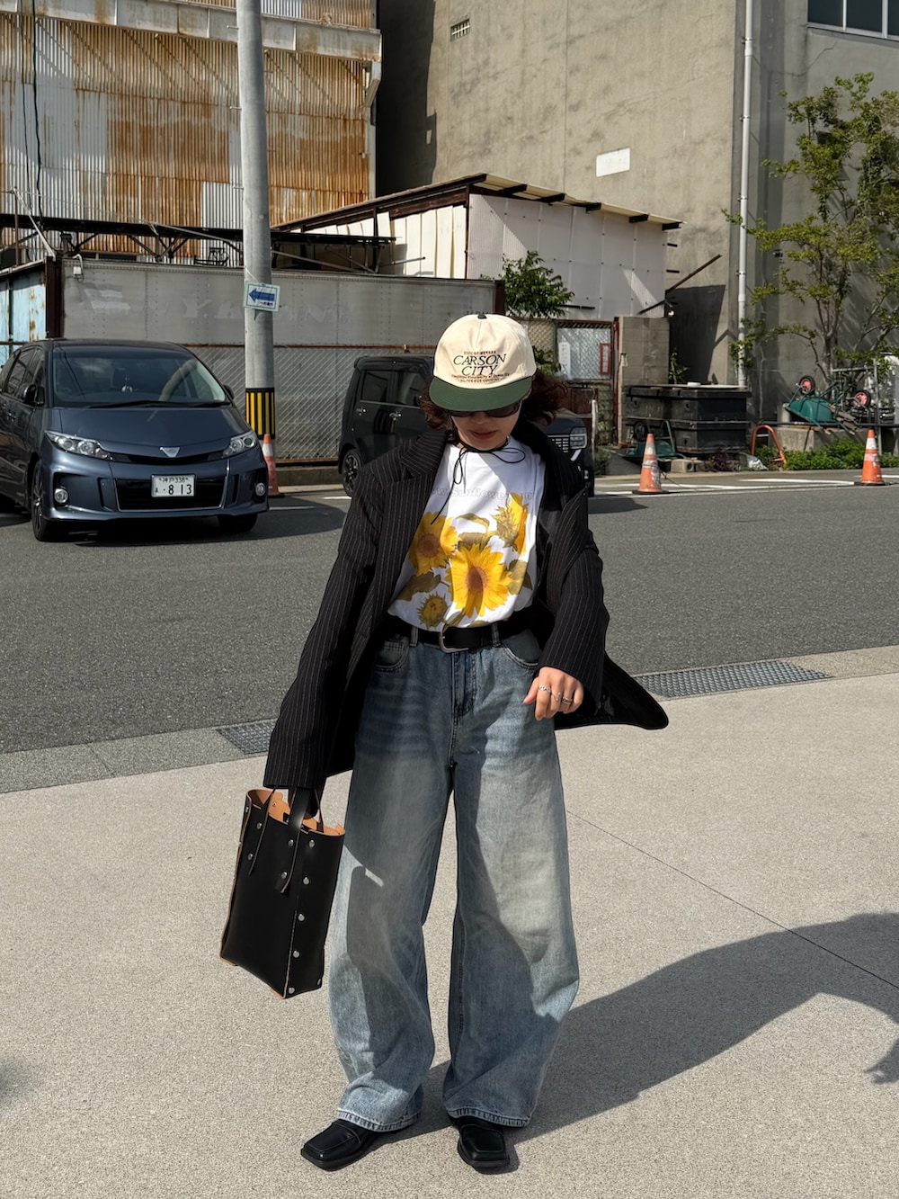 ブラック系のハンドバッグ、ホワイト系のTシャツ/カットソー、ブラック系のジャケット/アウターを着用したレディースの春コーディネートの3枚目の写真