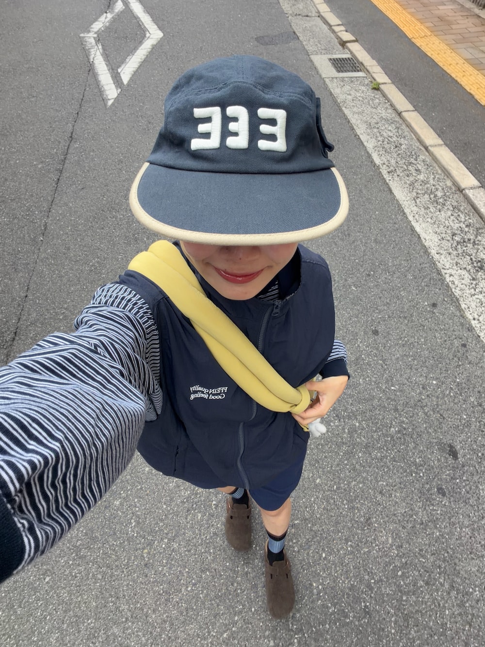ブルー系のTシャツ/カットソー、イエロー系のハンドバッグ、ブルー系のベストを着用したレディースの秋コーディネートの3枚目の写真
