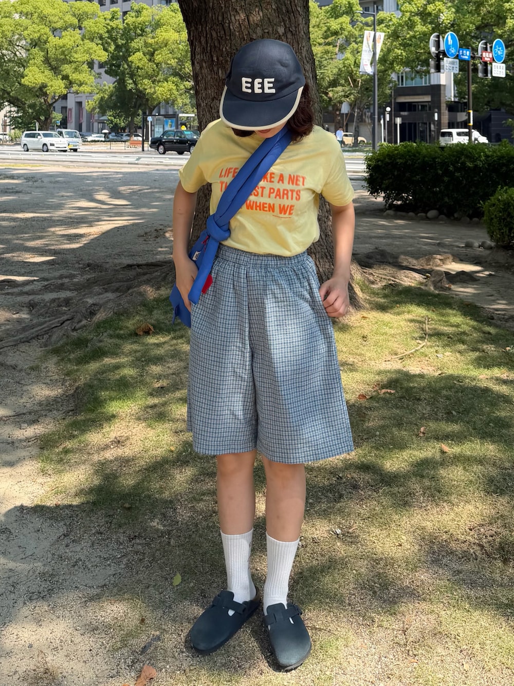 イエロー系のTシャツ/カットソー、ブルー系のサンダル、ブルー系のハンドバッグを着用したレディースの夏コーディネートの2枚目の写真