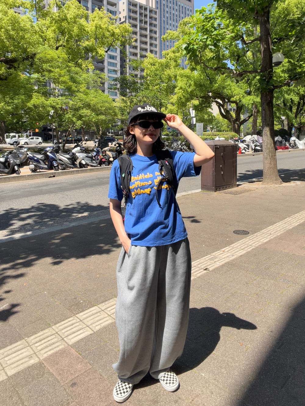 ブルー系のTシャツ/カットソー、ブラック系のバックパック/リュック、ブラック系のスリッポンを着用したレディースの春コーディネートの2枚目の写真