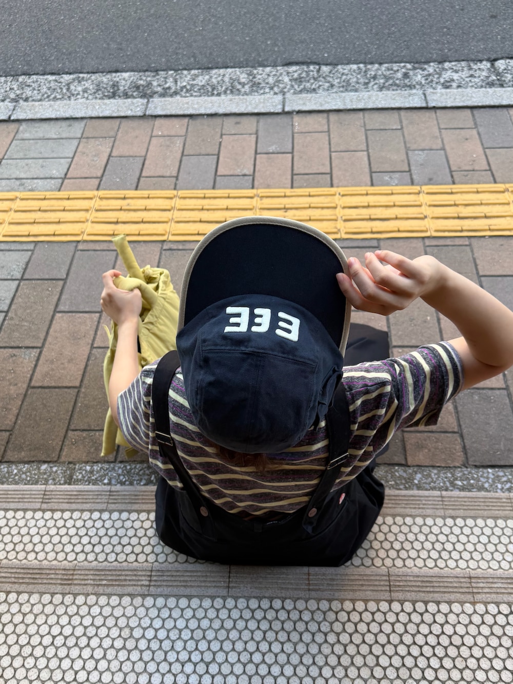 グレー系のTシャツ/カットソー、ブラック系のチノパンツ、イエロー系のハンドバッグを着用したレディースの秋コーディネートの3枚目の写真