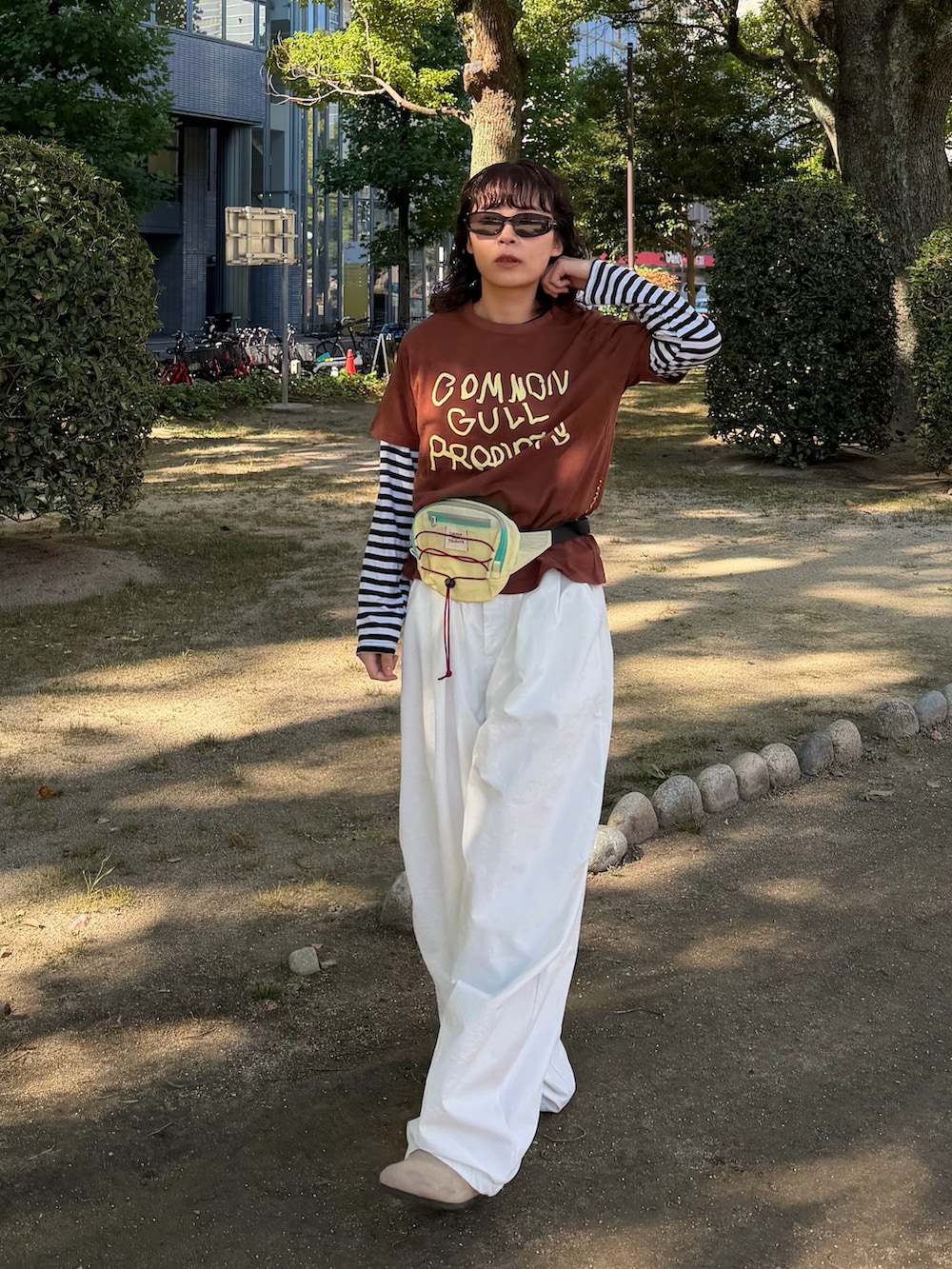 ブラウン系のTシャツ/カットソー、ブラック系のトップス、イエロー系のボディバッグ/ウエストポーチを着用したレディースの秋コーディネートの3枚目の写真