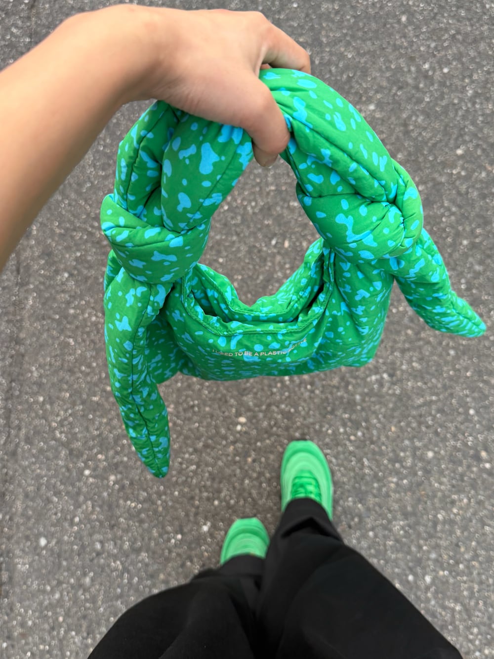 ホワイト系のトップス、ブラック系のチノパンツ、グリーン系のバッグを着用したレディースの夏コーディネートの3枚目の写真