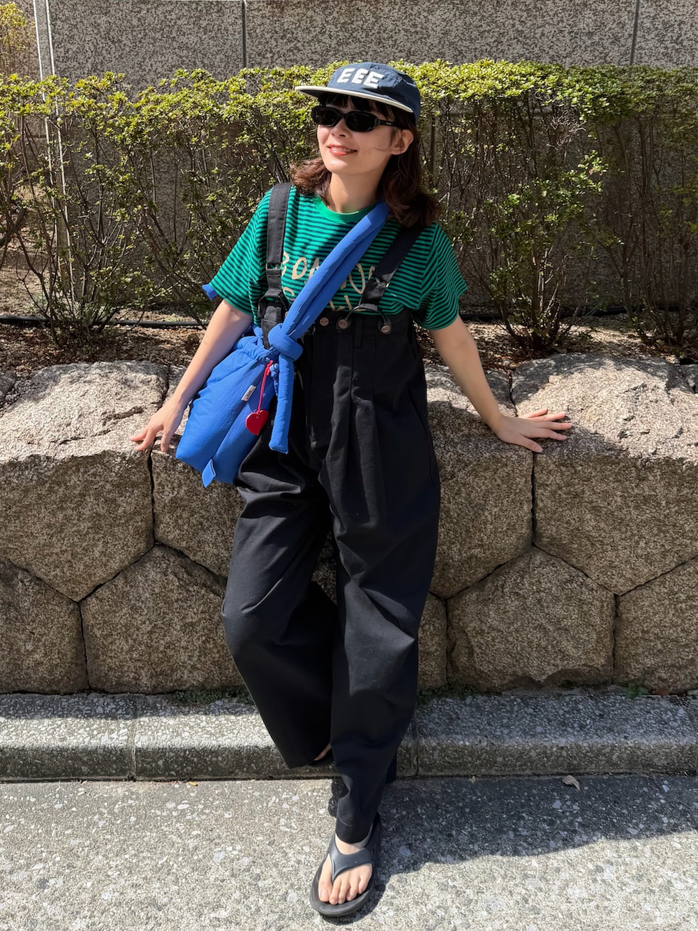 グレー系のTシャツ/カットソー、ベージュ系のチノパンツ、ブルー系のハンドバッグを着用したレディースの夏コーディネートの3枚目の写真