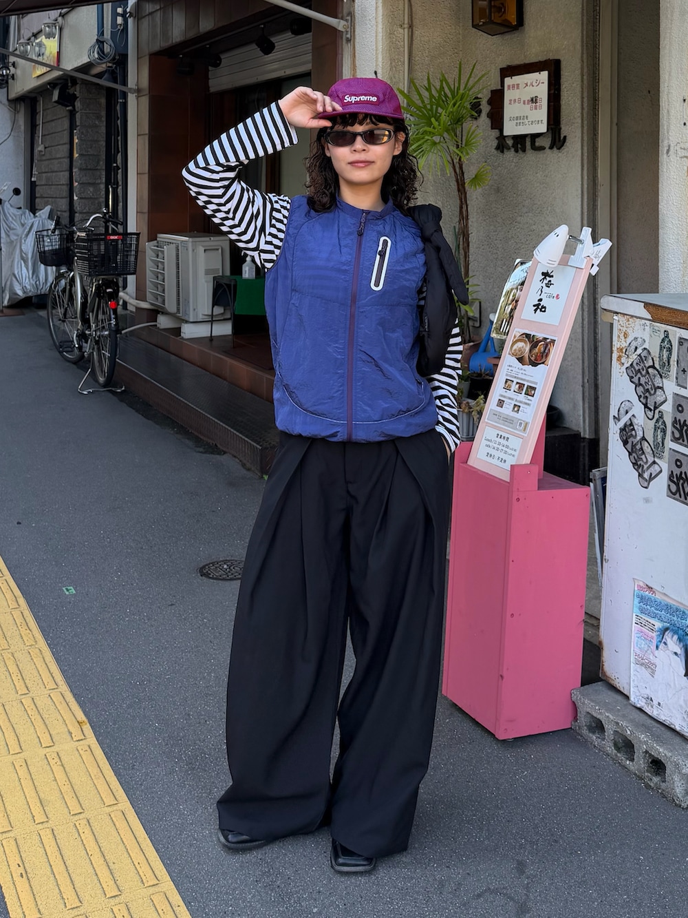 イエロー系のトップス、ブラック系のトップス、ブラック系のパンツを着用したレディースの秋コーディネートの2枚目の写真