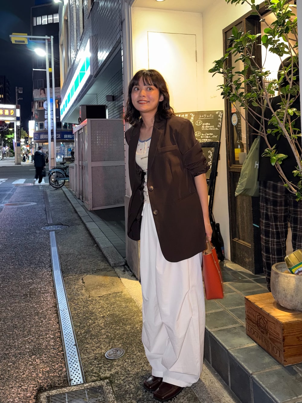 ブラウン系のジャケット/アウター、レッド系のタンクトップ、ホワイト系のキャミソールを着用したレディースの夏コーディネートの2枚目の写真