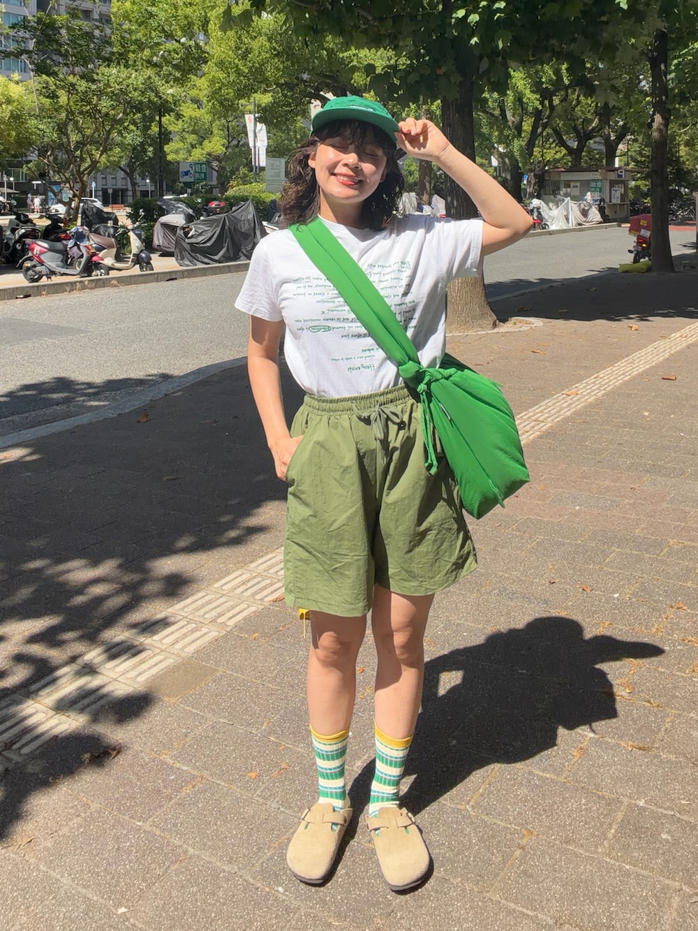 ホワイト系のTシャツ/カットソー、グリーン系のパンツ、ベージュ系のサンダルを着用したレディースの夏コーディネートの2枚目の写真