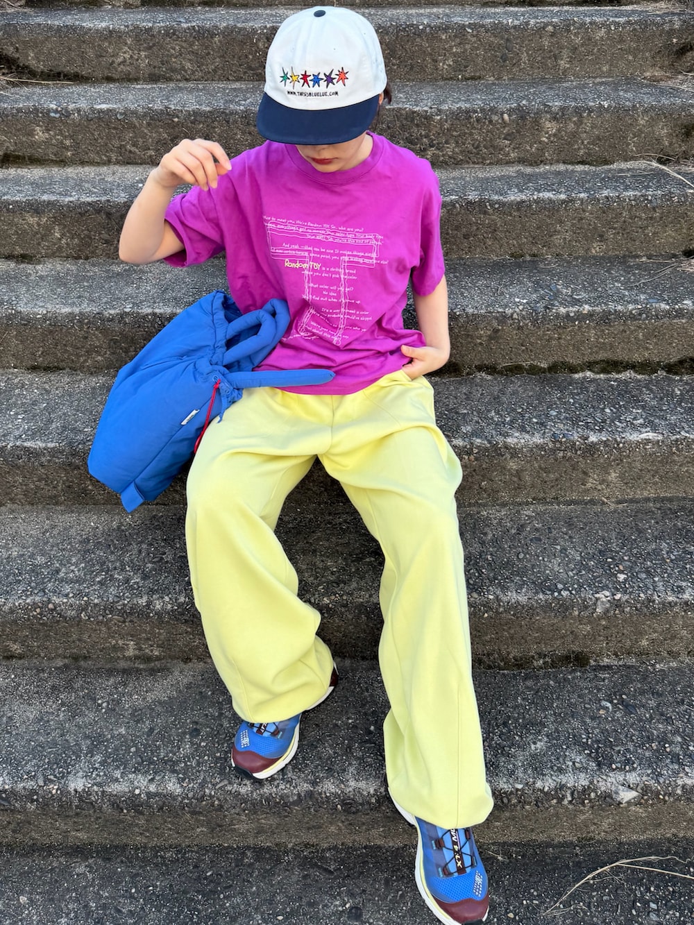 ブルー系のハンドバッグ、パープル系のTシャツ/カットソー、イエロー系のスウェットパンツを着用したレディースの夏コーディネートの3枚目の写真