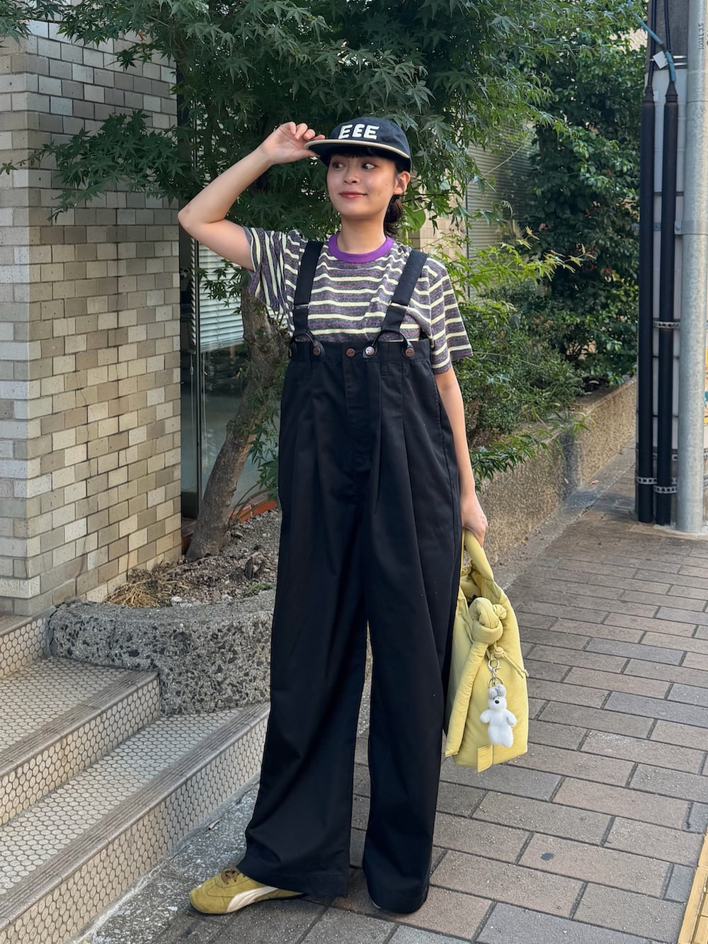 グレー系のTシャツ/カットソー、ブラック系のチノパンツ、イエロー系のハンドバッグを着用したレディースの秋コーディネートの2枚目の写真