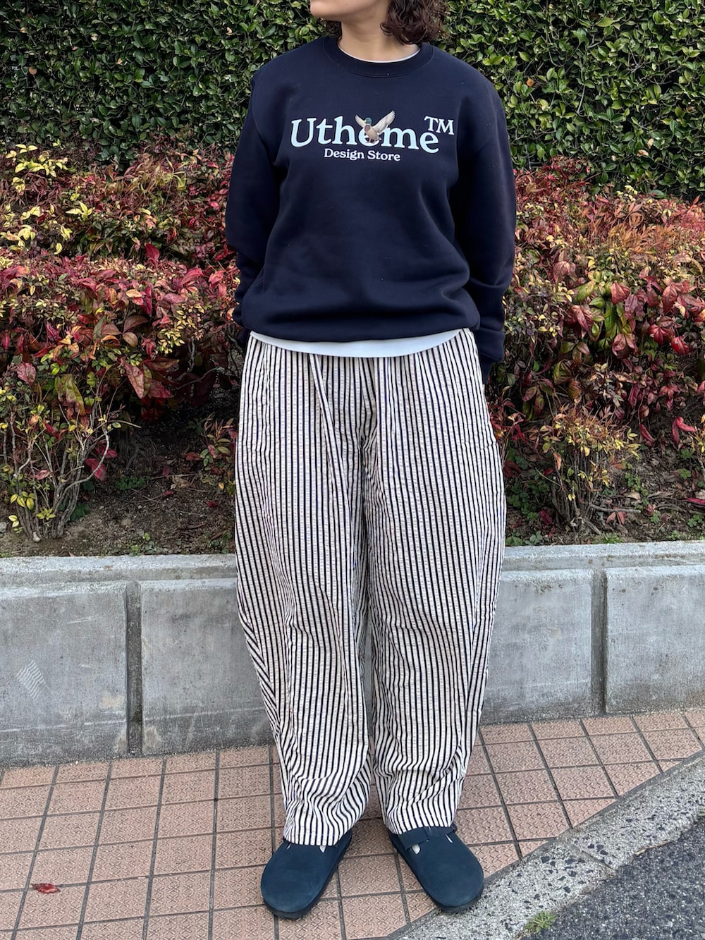 ブルー系のスウェット、ホワイト系のパンツ、ブルー系のサンダルを着用したレディースの春コーディネートの3枚目の写真