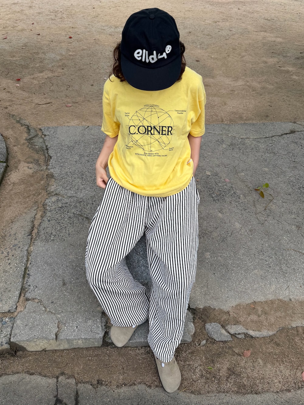 イエロー系のTシャツ/カットソー、ベージュ系のサンダル、ホワイト系のパンツを着用したレディースの夏コーディネートの3枚目の写真