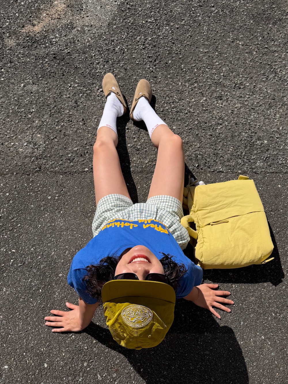 ブルー系のTシャツ/カットソー、イエロー系のその他パンツ、イエロー系のハンドバッグを着用したレディースの春コーディネートの3枚目の写真
