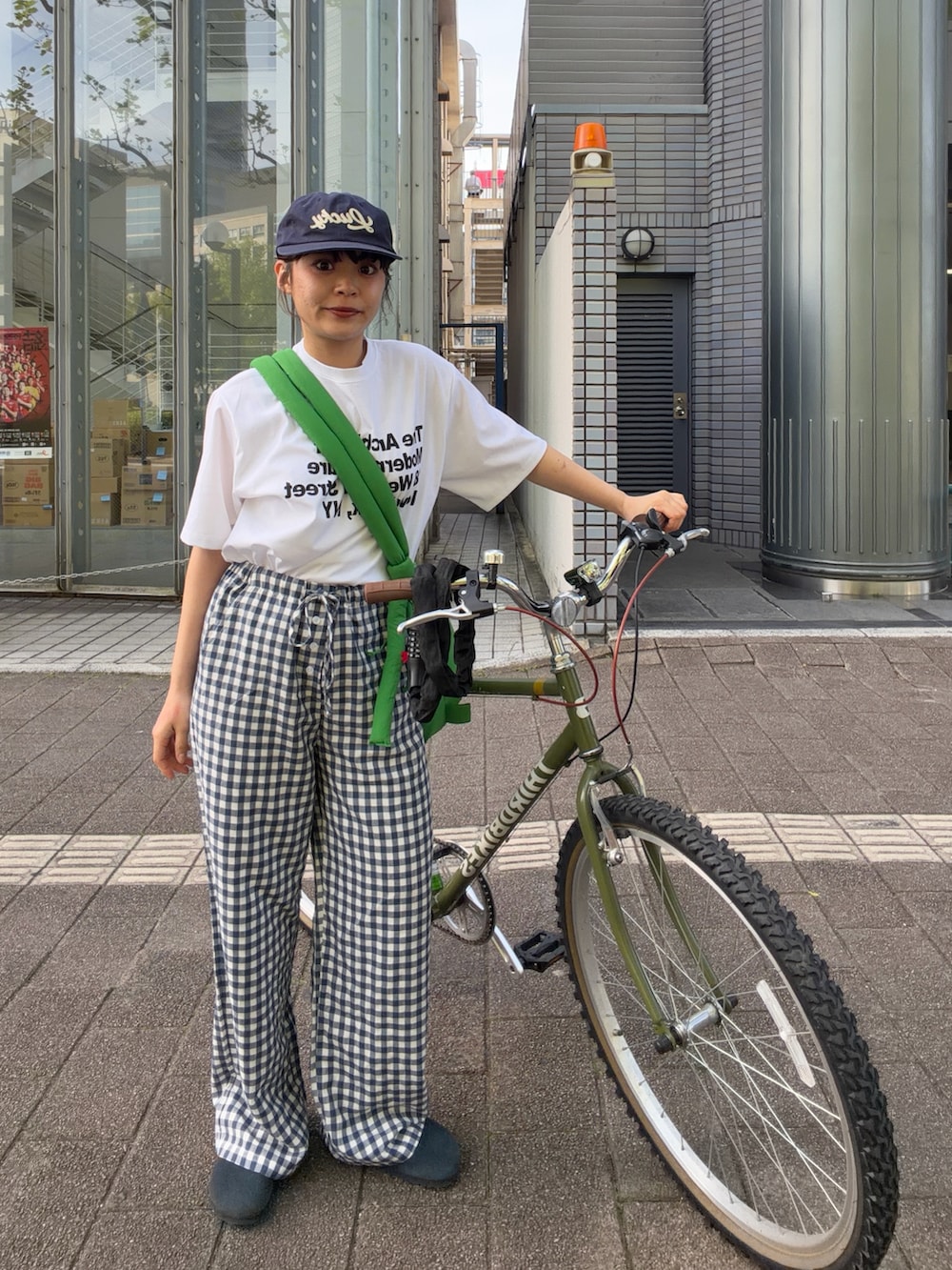 ホワイト系のTシャツ/カットソー、グリーン系のハンドバッグ、ブルー系のパンツを着用したレディースの春コーディネートの3枚目の写真
