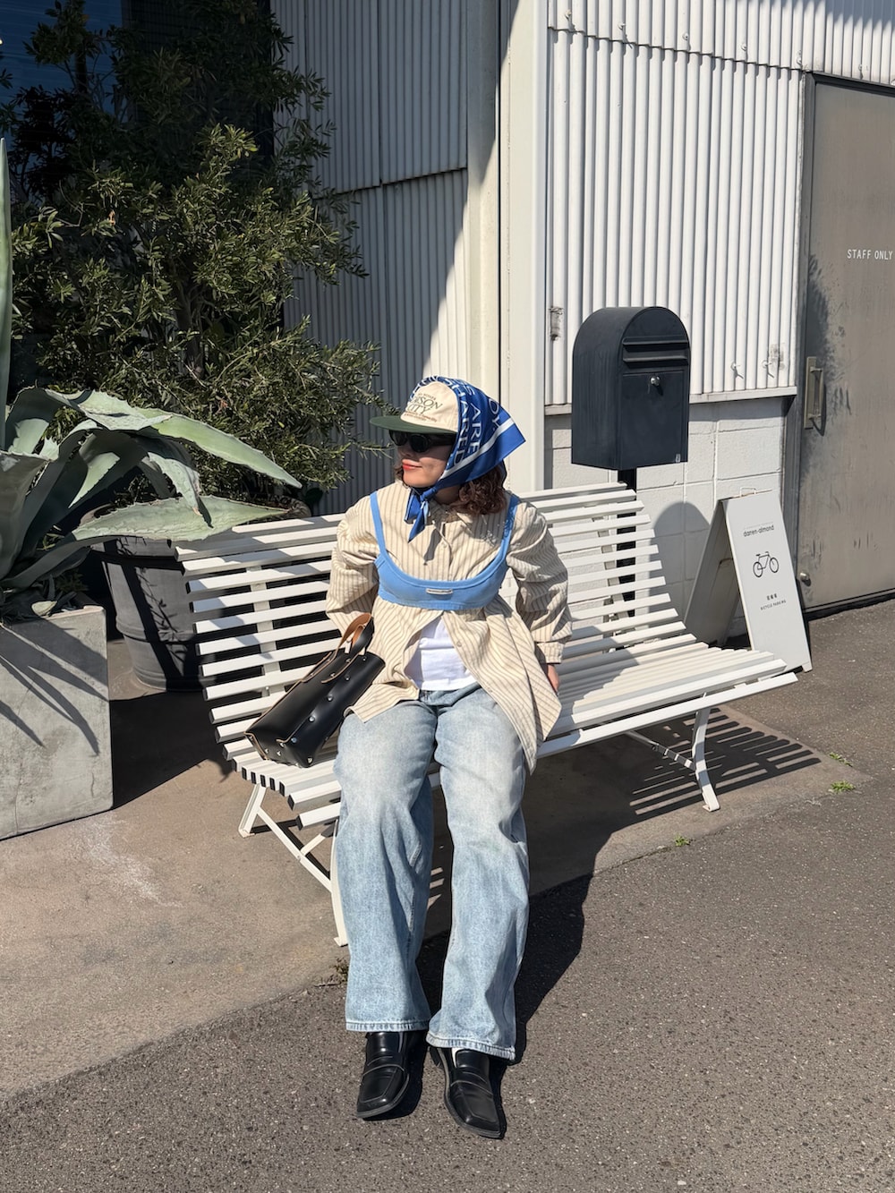 ブルー系のキャミソール、ベージュ系のシャツ/ブラウス、ブルー系のデニムパンツを着用したレディースの春コーディネートの3枚目の写真