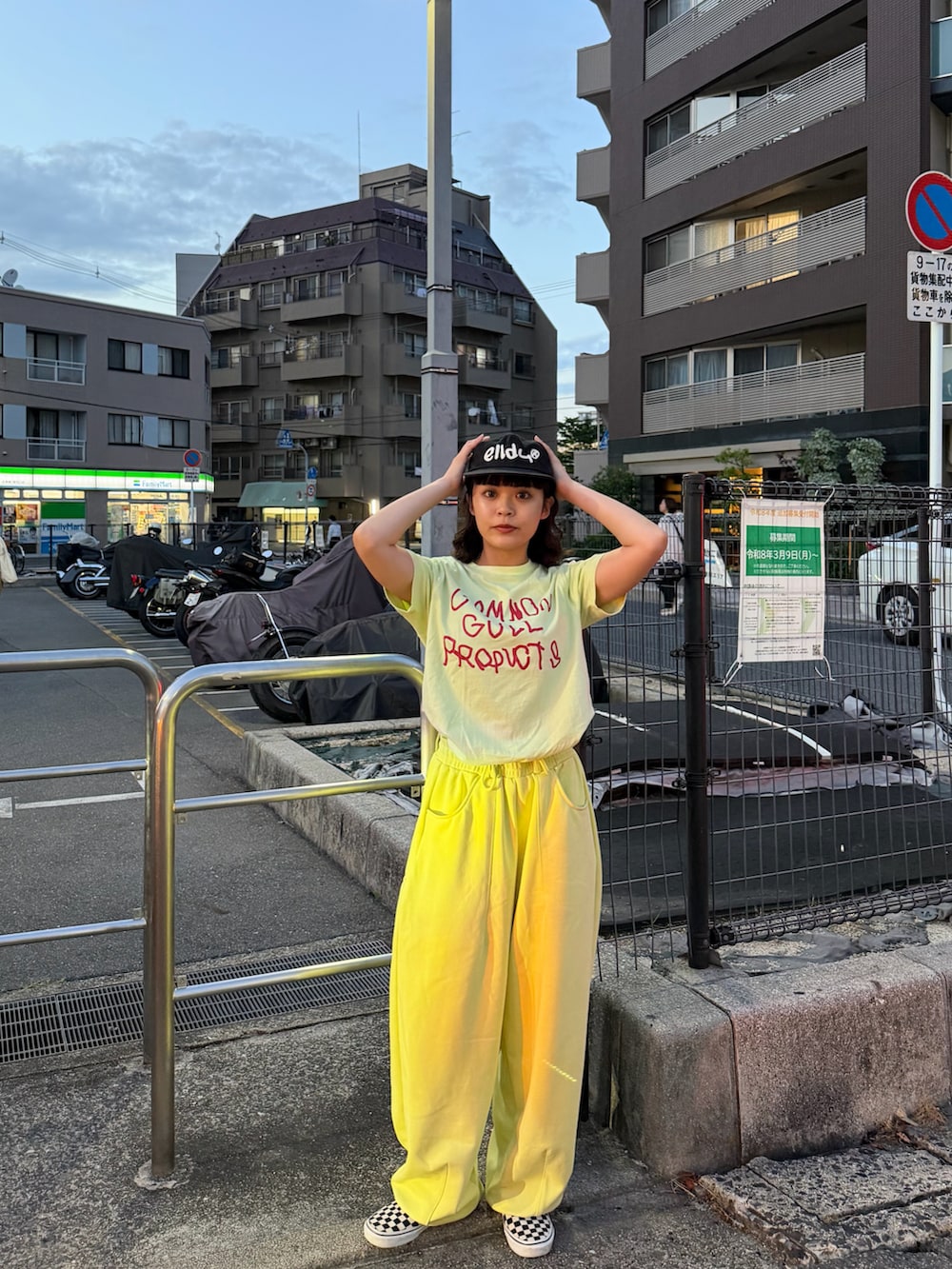 ブラック系のスリッポン、グリーン系のTシャツ/カットソー、イエロー系のスウェットパンツを着用したレディースの春コーディネートの2枚目の写真