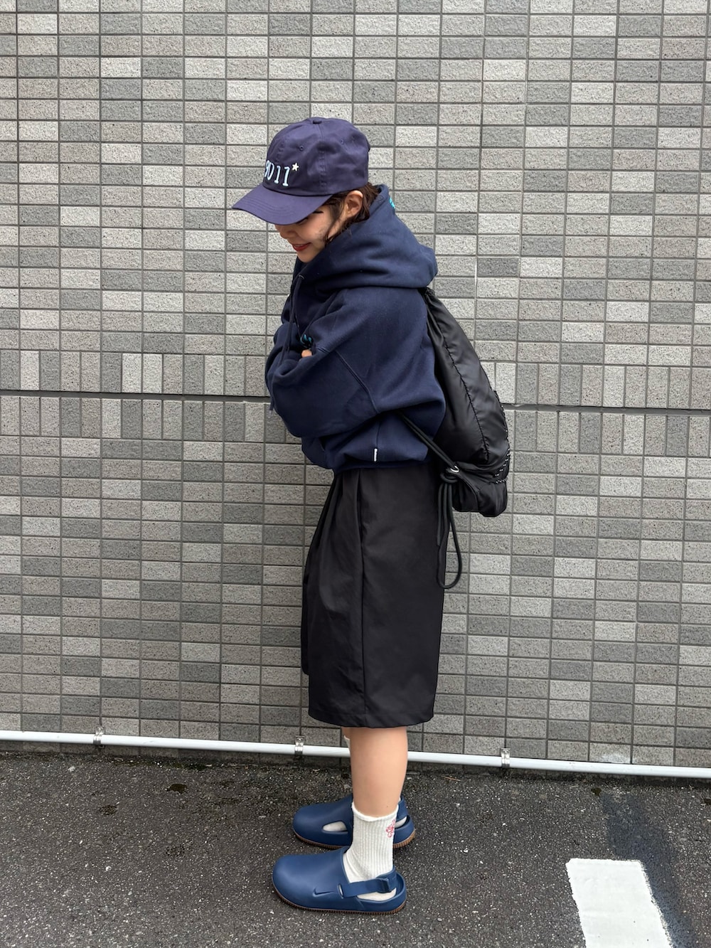 ブルー系のパーカー、ブラック系のバックパック/リュック、ブラック系のパンツを着用したレディースの春コーディネートの3枚目の写真