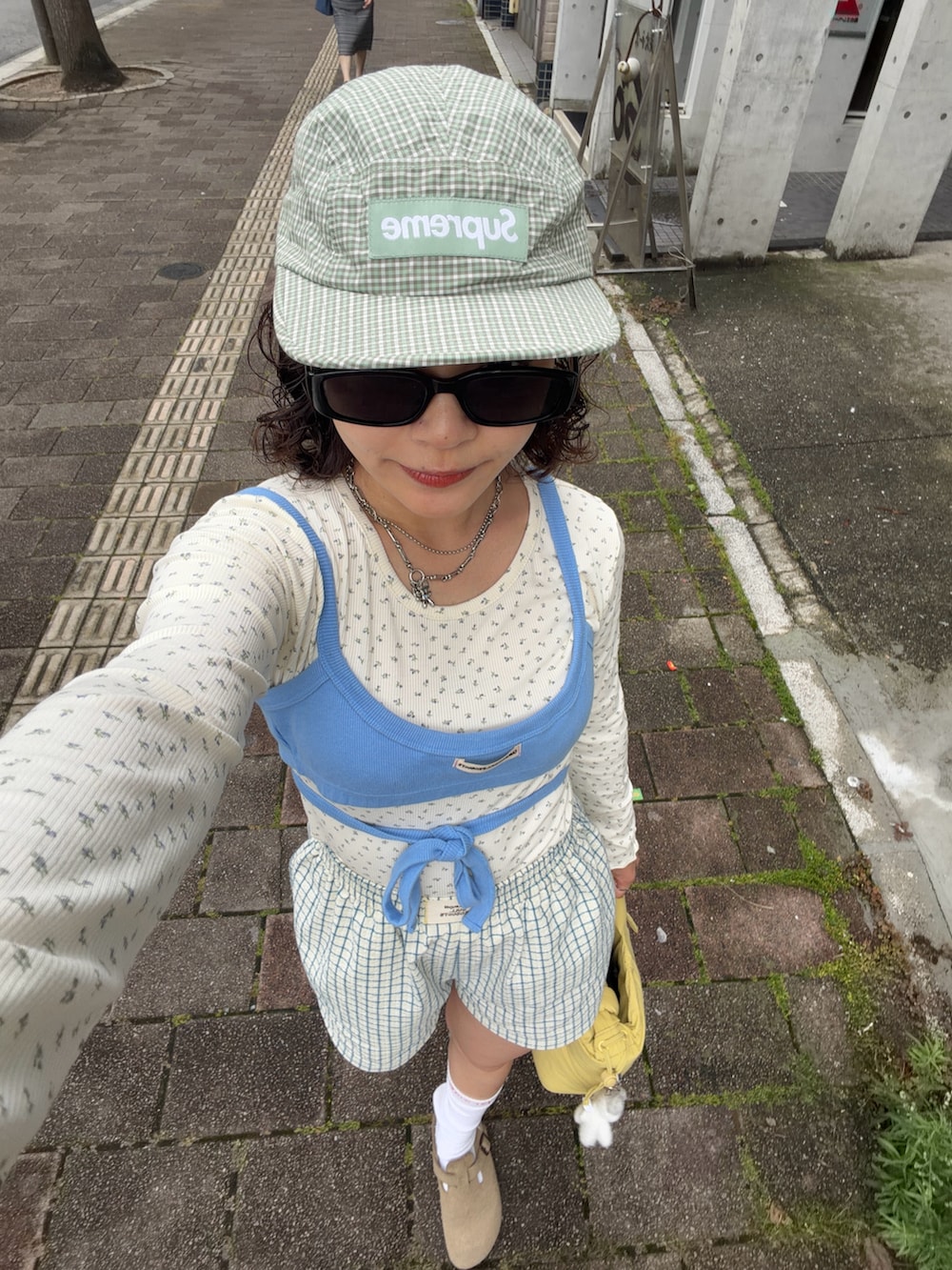 ブルー系のキャミソール、ホワイト系のトップス、イエロー系のその他パンツを着用したレディースの夏コーディネートの3枚目の写真