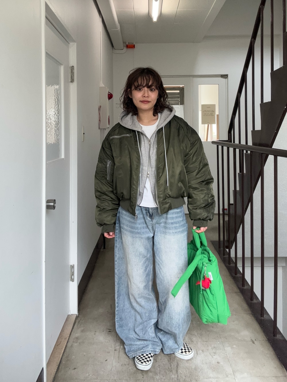 グリーン系のMA-1、グレー系のトップス、ホワイト系のTシャツ/カットソーを着用したレディースの春コーディネートの2枚目の写真