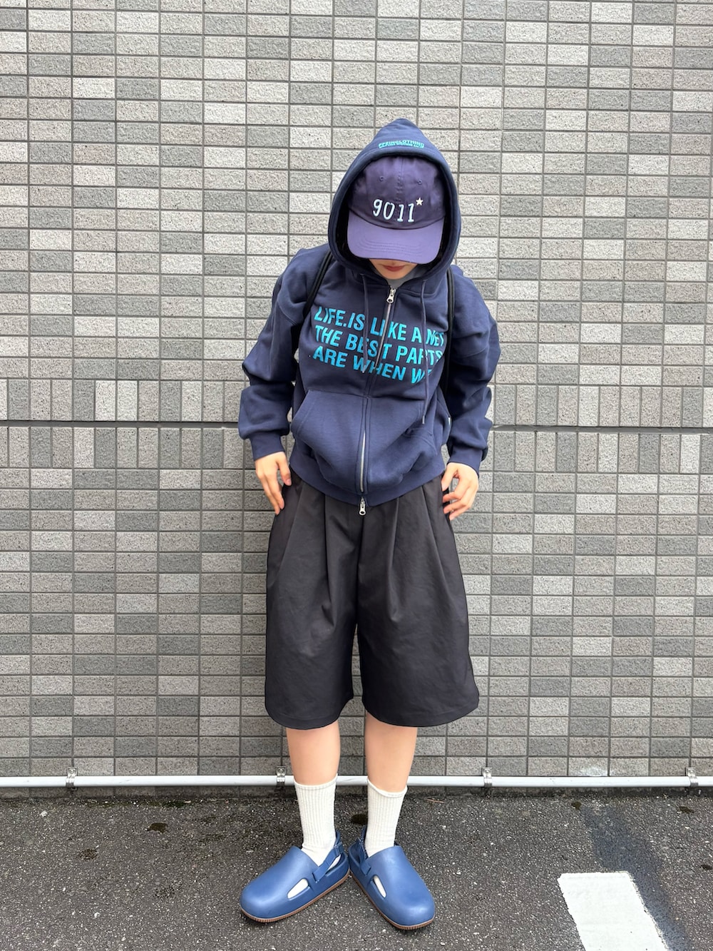 ブルー系のパーカー、ブラック系のバックパック/リュック、ブラック系のパンツを着用したレディースの春コーディネートの2枚目の写真