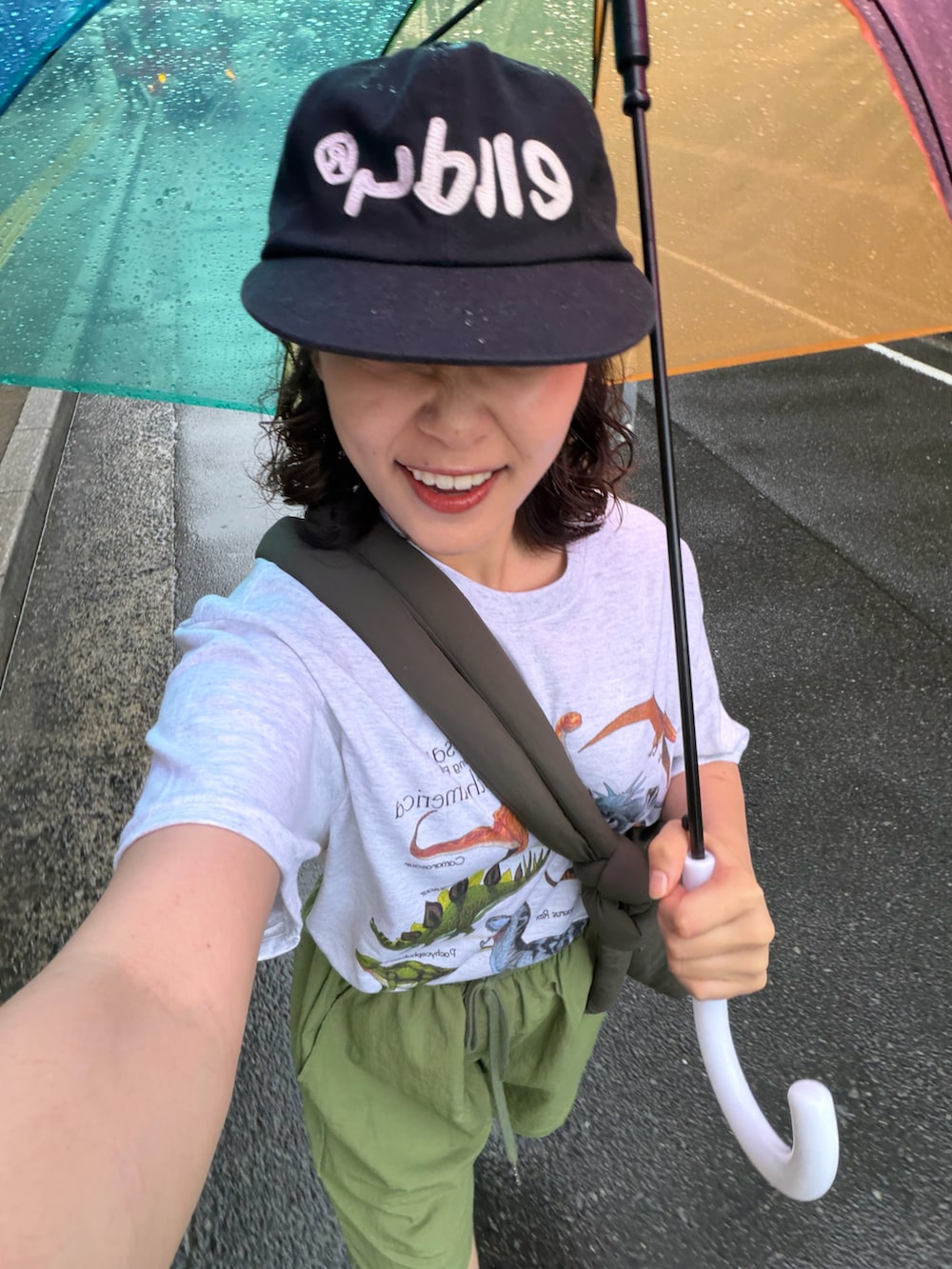 グリーン系のショルダーバッグ、グリーン系のパンツ、シルバー系のTシャツ/カットソーを着用したレディースの夏コーディネートの3枚目の写真