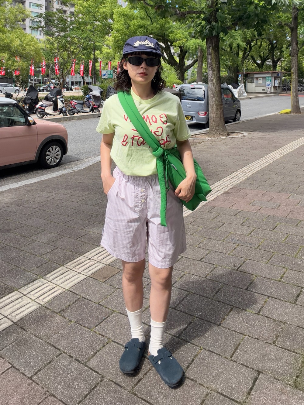 ブルー系のサンダル、グリーン系のTシャツ/カットソー、グリーン系のハンドバッグを着用したレディースの夏コーディネートの2枚目の写真