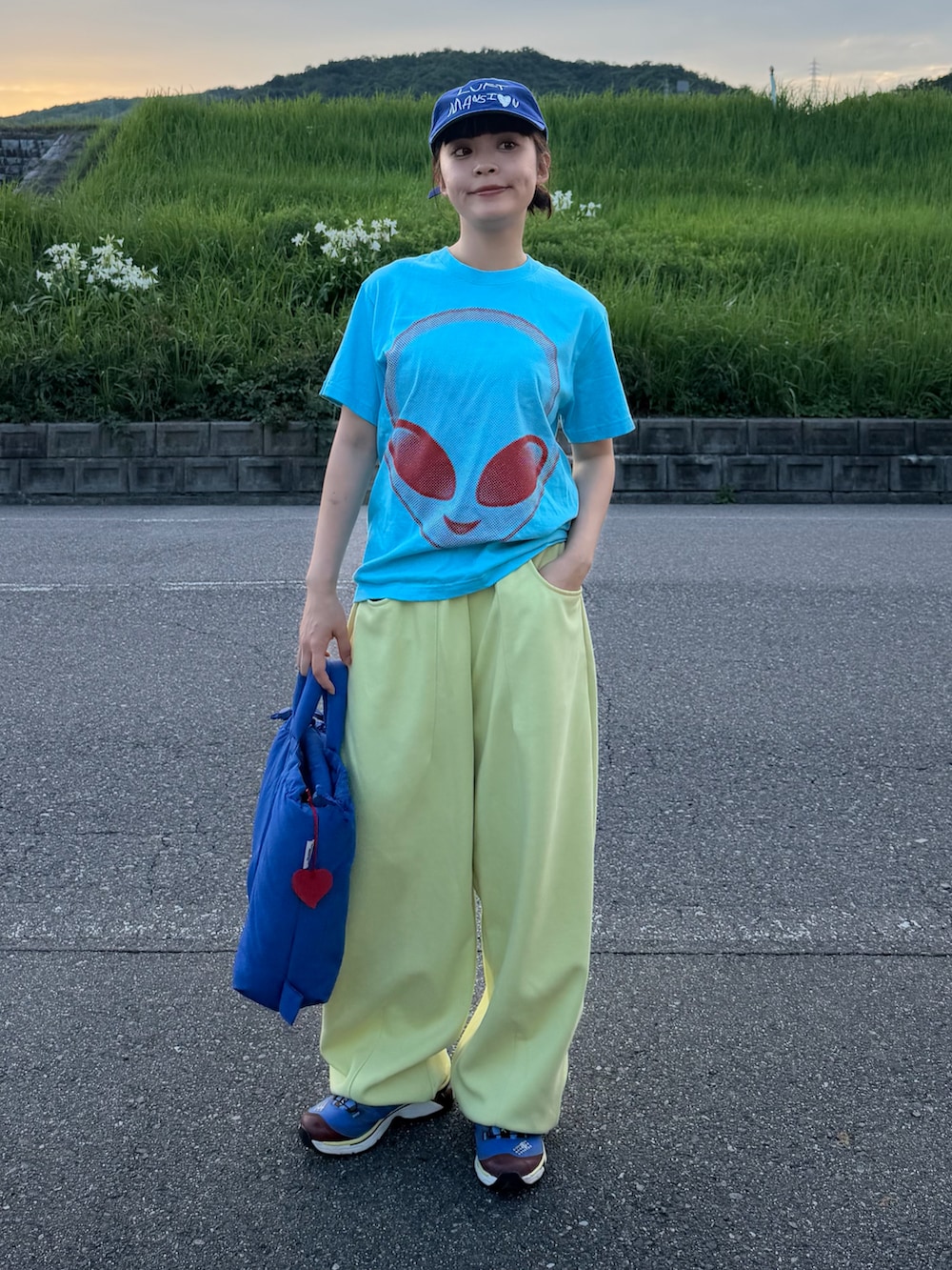 ブルー系のハンドバッグ、ブルー系のトップス、イエロー系のスウェットパンツを着用したレディースの夏コーディネートの3枚目の写真