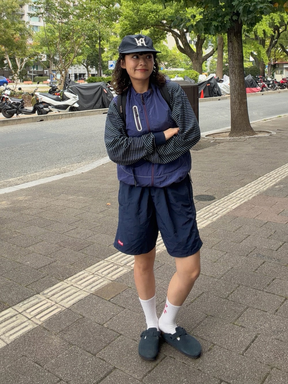 イエロー系のトップス、ブルー系のTシャツ/カットソー、ブルー系のパンツを着用したレディースの秋コーディネートの2枚目の写真