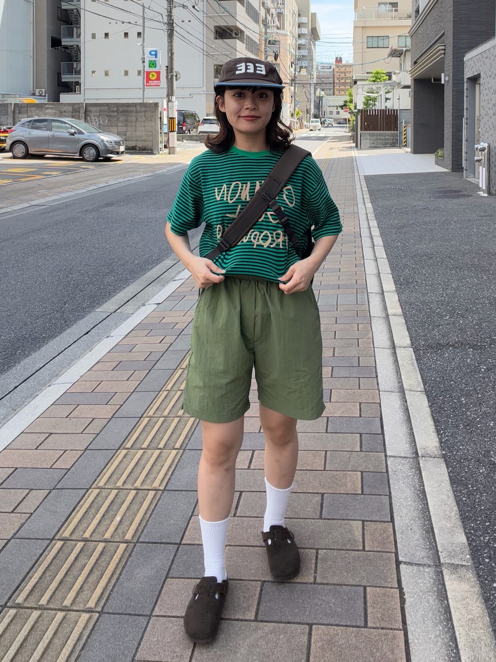グリーン系のTシャツ/カットソー、グリーン系のパンツ、ブラウン系のショルダーバッグを着用したレディースの夏コーディネートの2枚目の写真