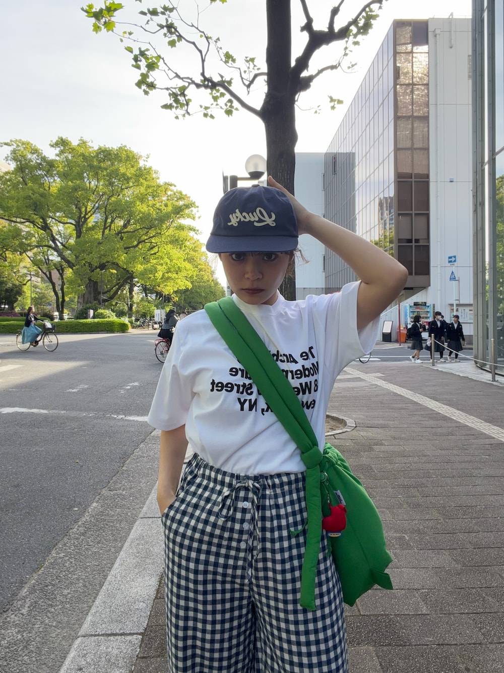 ホワイト系のTシャツ/カットソー、グリーン系のハンドバッグ、ブルー系のパンツを着用したレディースの春コーディネートの2枚目の写真
