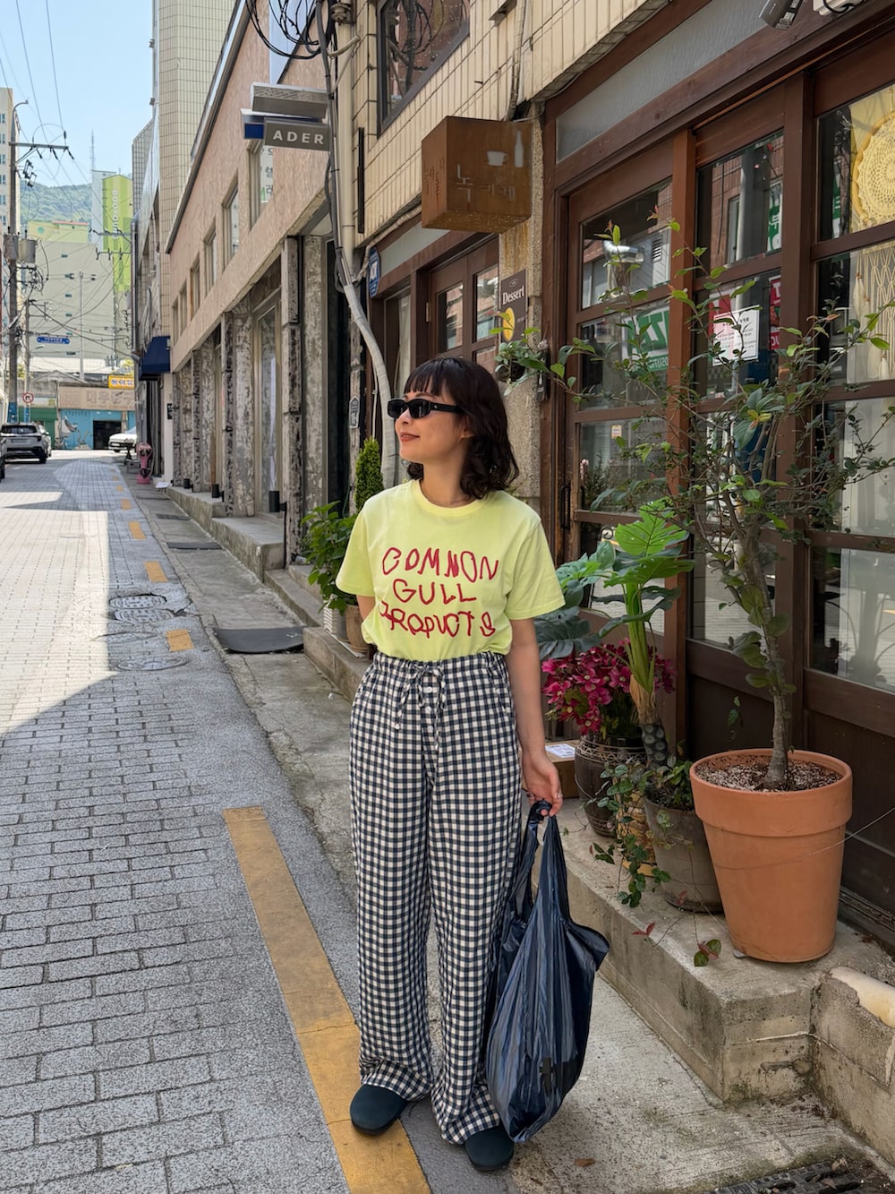 グリーン系のTシャツ/カットソー、ブルー系のパンツ、ブルー系のサンダルを着用したレディースの春コーディネートの2枚目の写真