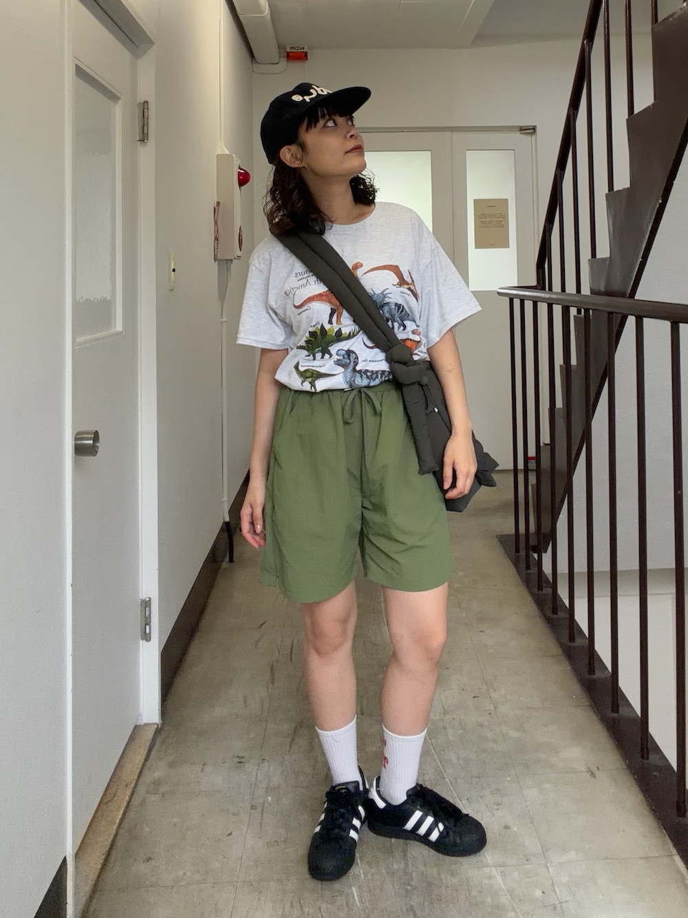 グリーン系のショルダーバッグ、グリーン系のパンツ、シルバー系のTシャツ/カットソーを着用したレディースの夏コーディネートの2枚目の写真