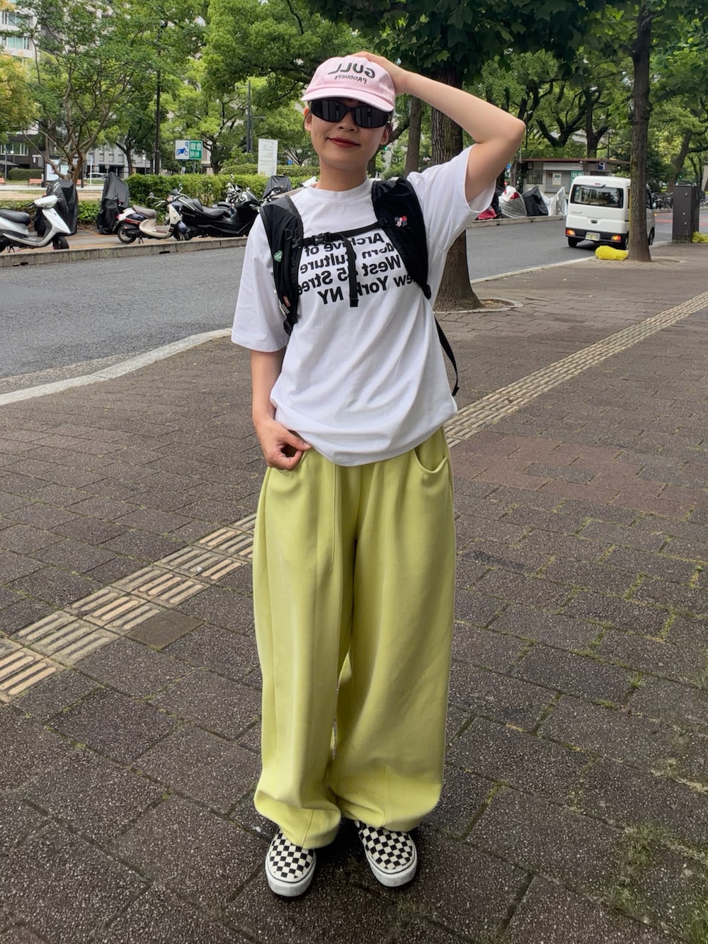 ホワイト系のTシャツ/カットソー、ブラック系のバックパック/リュック、イエロー系のスウェットパンツを着用したレディースの夏コーディネートの2枚目の写真