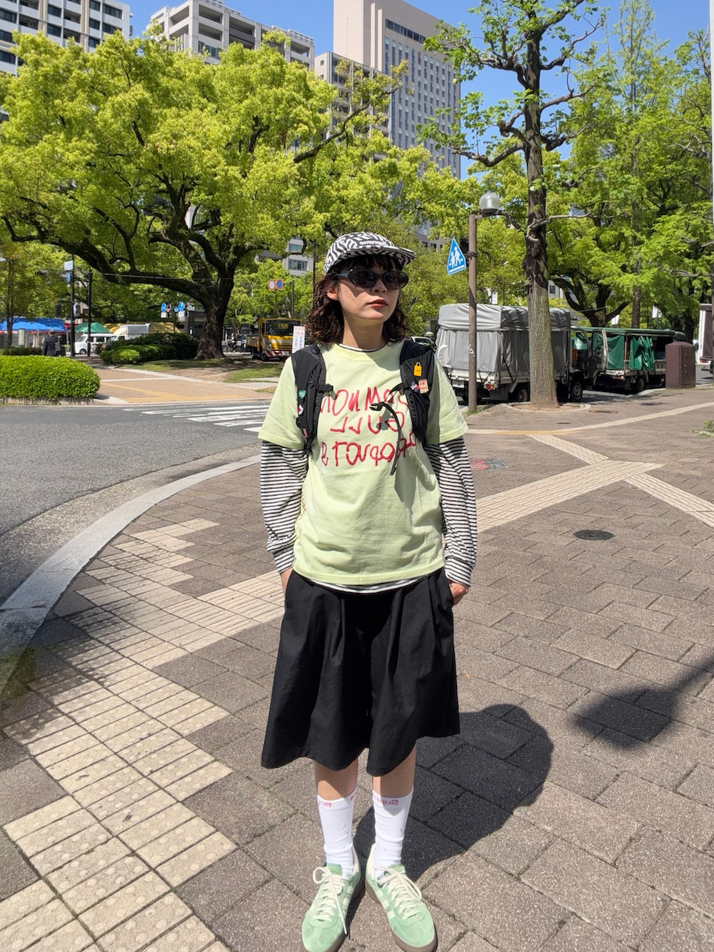 グリーン系のスニーカー、グリーン系のTシャツ/カットソー、ブラック系のバックパック/リュックを着用したレディースの春コーディネートの2枚目の写真