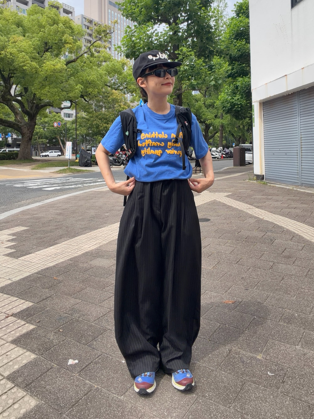 ブルー系のTシャツ/カットソー、ブラック系のパンツ、ブルー系のシューズを着用したレディースの夏コーディネートの2枚目の写真