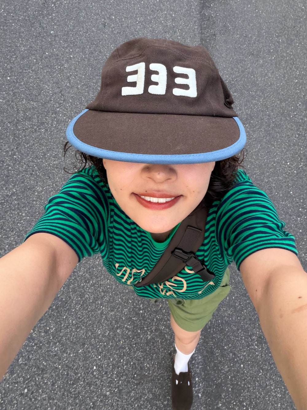 グリーン系のTシャツ/カットソー、グリーン系のパンツ、ブラウン系のショルダーバッグを着用したレディースの夏コーディネートの3枚目の写真